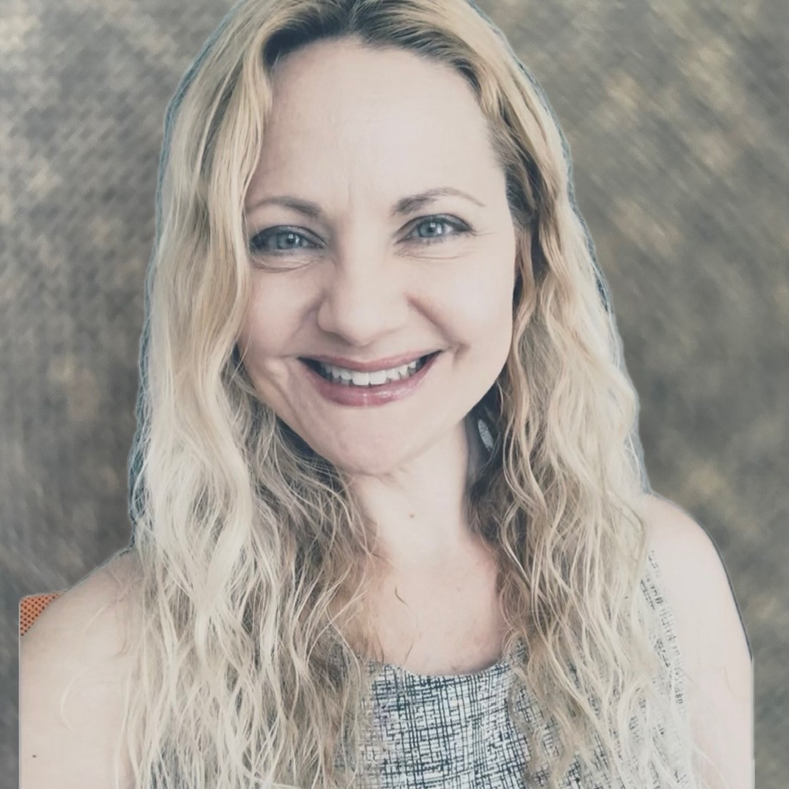 A woman with long, wavy blonde hair and light eyes is smiling at the camera. She is wearing a sleeveless patterned top, and the background is a blurred, textured brown.