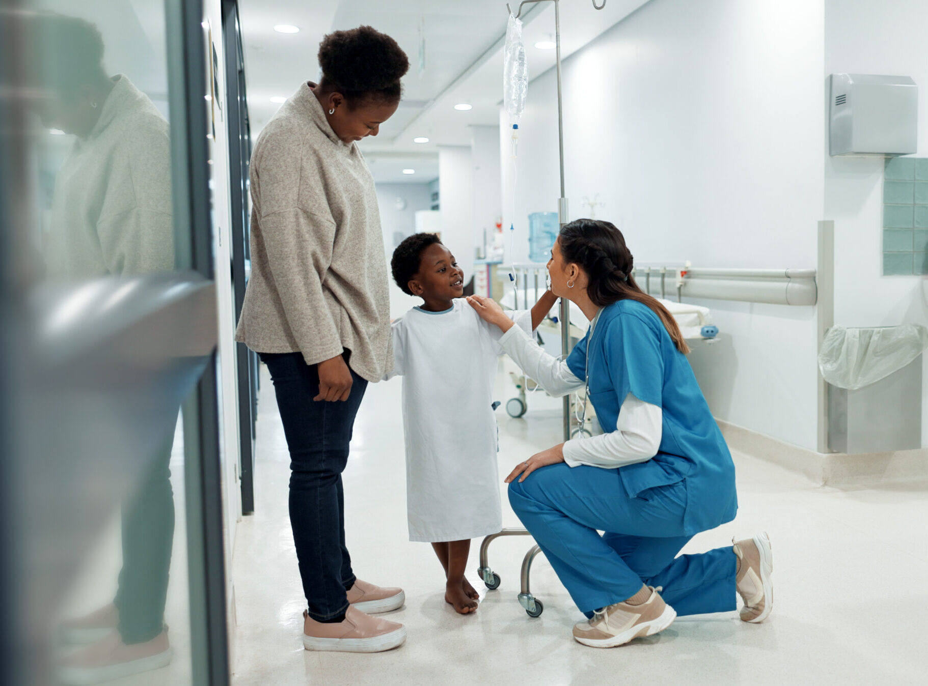 Black family, healthcare and a pediatrician talking to a patient in the hospital for medical child care. Kids, trust or medicine and a nurse consulting a boy with his mother in the clinic for health.