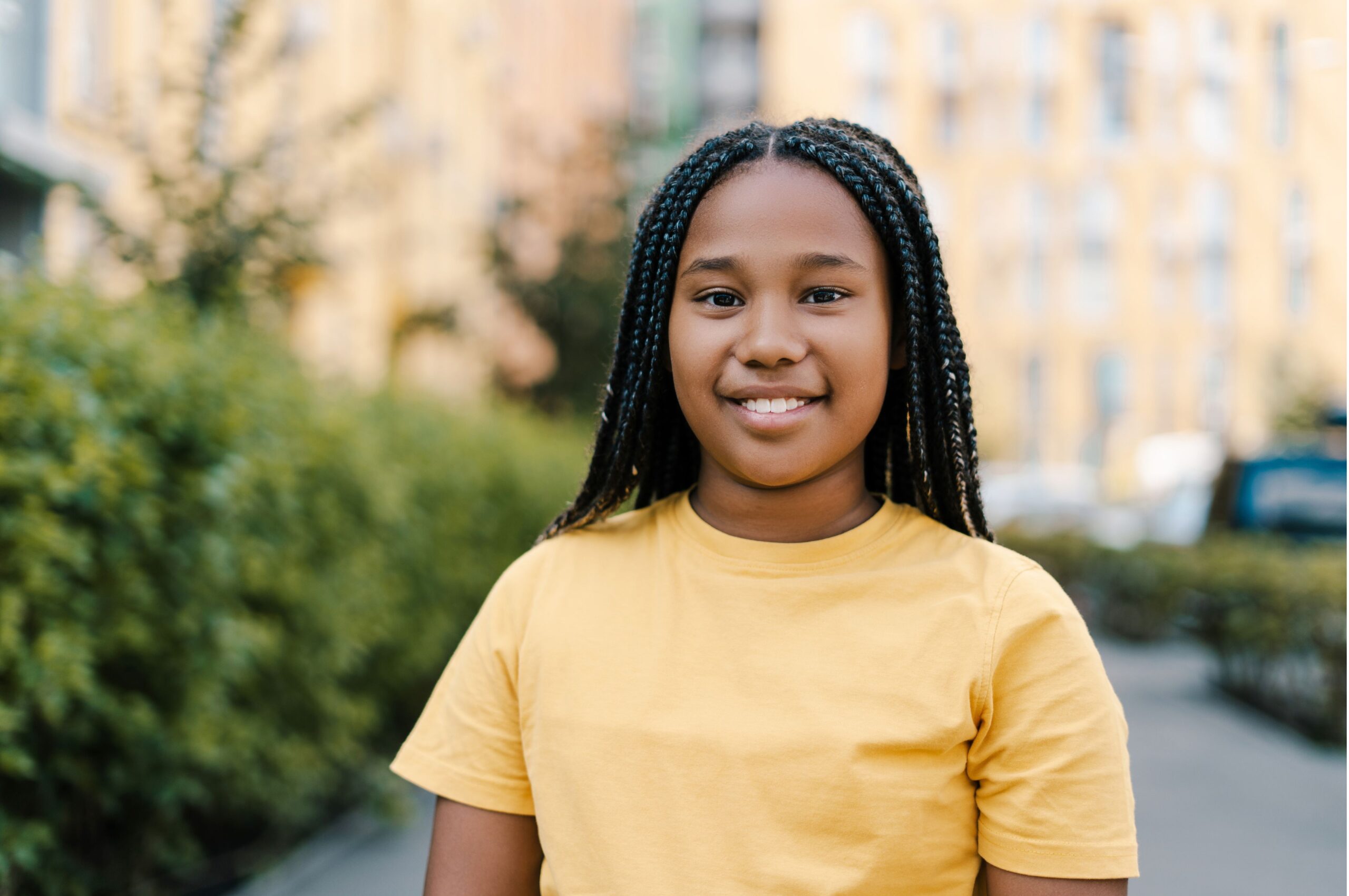 Adolescent girl standing in front of a hospital.